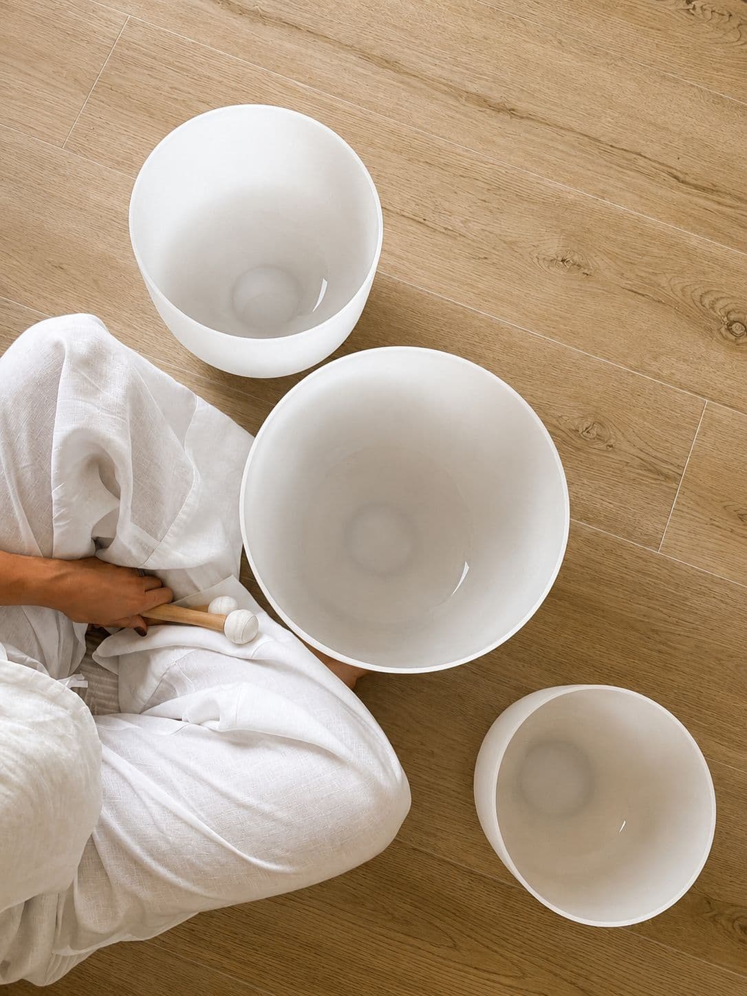 Crystal singing bowls on warm wood floor - Sound Studio